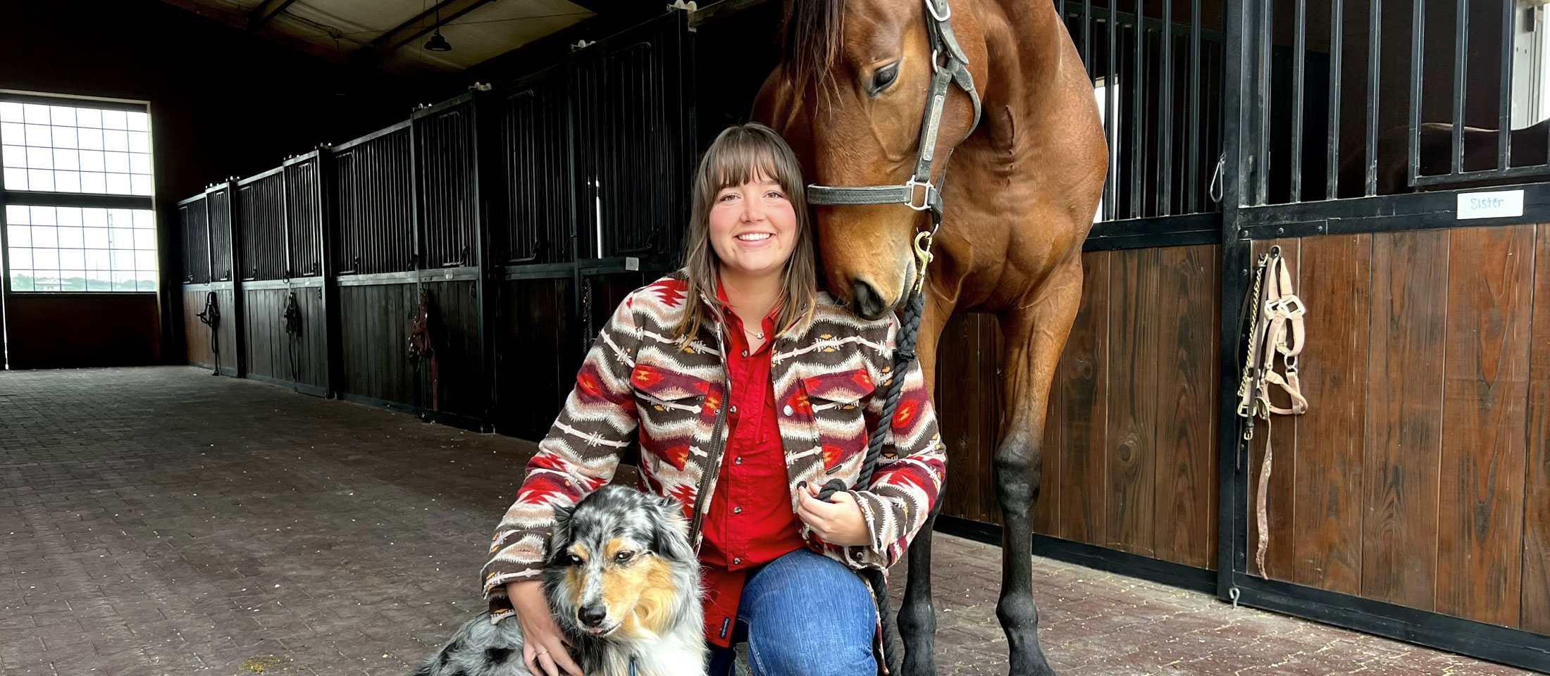 Abby, posing next to her horse and her Australian shepherd dog.